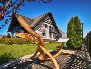 a statue of a bench in front of a building at Pod Strzechą in Darłowo