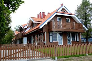 a wooden fence in front of a house at Preilos Vėtra 1 in Preila