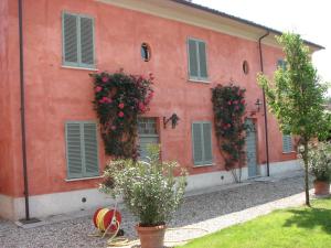 an orange building with flowers on the side of it at Country House La Viscarda in Tortona