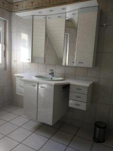 a white bathroom with a sink and a mirror at Hotel Am Markt in Ehrenfriedersdorf