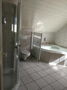 y baño con bañera, aseo y lavamanos. en Hotel Am Markt, en Ehrenfriedersdorf