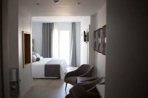 una camera d'albergo con letto e sedia di El Trebol Bar & Hotel Only Adults a Carboneras