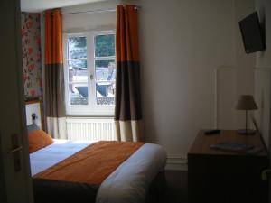 a bedroom with a bed and a window at Logis - Hôtel & Restaurant Le Bellevue in La Bouille