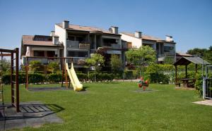 un parco giochi di fronte a un grande edificio di Lauri & Faggi a Desenzano del Garda