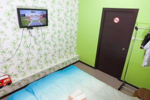 ヤクーツクにあるHostels Rus - Yakutskのベッドルーム1室(ベッド1台、壁掛けテレビ付)
