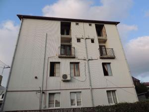 a large white building with windows on the side of it at Vacation Home Gela in Batumi