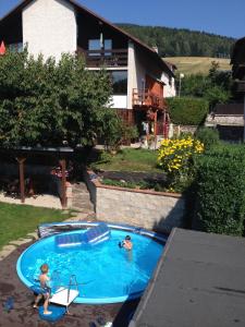 two children playing in a swimming pool in a backyard at Dům Jaroslava in Černý Dŭl