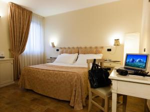 a hotel room with a bed and a desk with a computer at Locanda Del Parco Hotel in Colledara