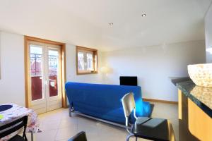 a living room with a blue couch and a table at Bright Sao Domingos Apartments in Viana do Castelo