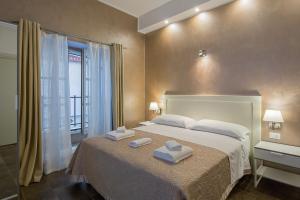a hotel room with a bed and two lamps at Vela Rooms in Cagliari