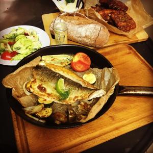 諾夫梅斯托納馬瑞夫的住宿－奧爾尼德瓦爾酒店，桌上满是鱼和蔬菜的锅