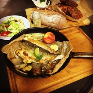 a pan filled with fish and vegetables on a table at Hotel Horní Dvůr in Nové Město na Moravě