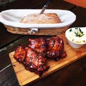 una tabla de cortar de madera con costillas y una cesta de pan en Hotel Horní Dvůr, en Nové Město na Moravě