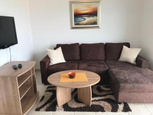 a living room with a brown couch and a coffee table at Apartmani Marija Klimno B in Klimno