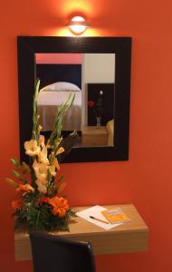 a mirror on a wall with a vase of flowers at Hotel Riomar in Lagos