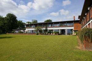 un bâtiment avec une grande pelouse devant lui dans l'établissement Hotel Hesselet, à Nyborg