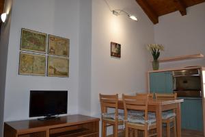 a dining room with a television and a table with chairs at Casa River - CIPAT 022006-AT-059712 in Arco