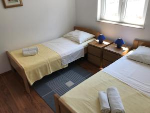 a room with two beds and two lamps on tables at Apartmani Marija Klimno B in Klimno