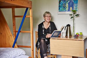 an older woman sitting at a desk with a laptop at Roslev Vandrerhjem-Hostel in Roslev
