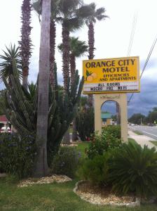 ein orangefarbenes Motel-Schild neben einer Palme in der Unterkunft Orange City Motel - Orange City in Orange City