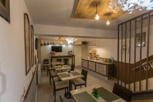 a restaurant with tables and chairs and a kitchen at Pensiunea Kant in Sibiu