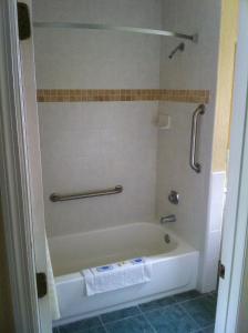 a bath tub in a bathroom with a shower at Orange City Motel - Orange City in Orange City