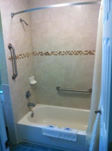 Das Bad ist mit einer Badewanne mit einer Dusche ausgestattet. in der Unterkunft Orange City Motel - Orange City in Orange City