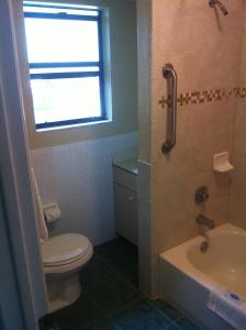 La salle de bains est pourvue de toilettes, d'un lavabo et d'une douche. dans l'établissement Orange City Motel - Orange City, à Orange City