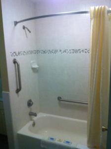 a bathroom with a tub and a shower with a shower curtain at Orange City Motel - Orange City in Orange City