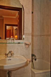y baño con lavabo, bañera y espejo. en Hostal Victoria III, en Madrid
