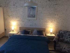 1 dormitorio con 1 cama azul y 2 lámparas en Dzirnaviņas en Biksti