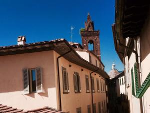 ein Gebäude mit einem Uhrturm in der Ferne in der Unterkunft Apartment Nel Centro Della Citta in Pistoia