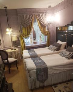 a bedroom with three beds and a chair and a window at Disayn Hotel Shampan in Stavropol