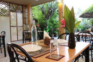 una mesa de madera con dos platos y una botella. en Hanifaru Transit Inn, en Dharavandhoo