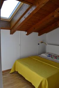 a bedroom with a yellow bed with a window at Casa River - CIPAT 022006-AT-059712 in Arco