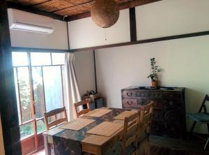 een eetkamer met een tafel en stoelen en een raam bij Murasakino Guesthouse in Kyoto