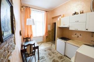 リヴィウにあるZamarstynivska apartmentの白いキャビネット、テーブルと椅子付きのキッチンが備わります。