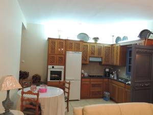 パノルモス・カリムノスにあるMarouso Villaのキッチン(木製キャビネット、白い冷蔵庫付)
