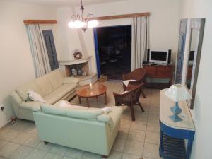 a living room with a couch and a table at Marouso Villa in Panormos Kalymnos