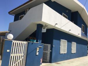 a blue and white building with a gate at Casa anticaglie P.Secca in Punta Secca