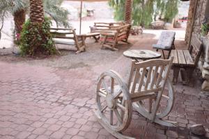 a group of benches and tables and a woodenoked wheel at Williams House in Eilat