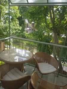 patio con mesa y sillas en el balcón en Riverside Apartments with Sauna en Palanga