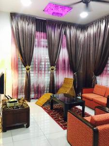 uma sala de estar com um sofá e uma mesa em Homestay Melaka Urich em Malaca