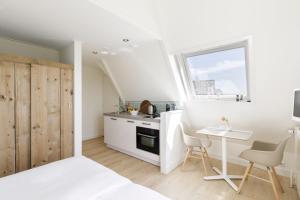 a kitchen with a small table and a kitchen with a window at Villa Parnassia in Bergen aan Zee +23 photos