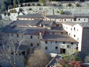 un grupo de edificios con techos de tejas en una colina en La Nicchia - Serena Tuscany Homes, en Cortona