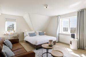 een slaapkamer met een bed en een woonkamer met een bank bij Villa Parnassia in Bergen aan Zee