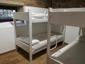 un letto a castello con 2 letti a castello in una camera di Albergue El Paso a Vega de Valcarce