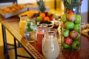 une table recouverte de bocaux de lait et de fruits dans l'établissement Pousada Convento de Tavira, à Tavira