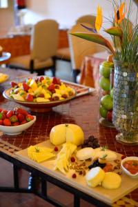 a table topped with plates of cheese and fruit at Pousada Convento de Tavira in Tavira