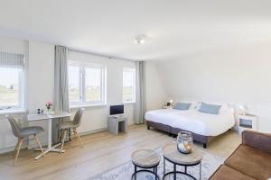 a bedroom with a bed and a living room at Villa Parnassia in Bergen aan Zee